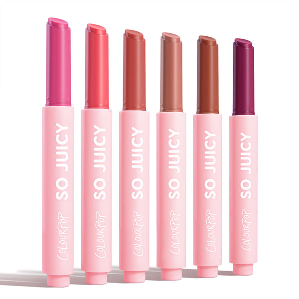 Six ColourPop So Juicy Plumping Gloss Balm with Peptides sticks, So Balm, stand upright and uncapped on a white background, displaying fuchsia, coral, rosy nude, beige, warm brown, and deep berry in pink tubes labeled SO JUICY.