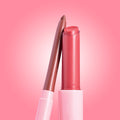 Rosy nude twist-up lip liner leans against an open glossy pink balm in sleek pink tubes on a gradient pink background; Glazed Pout ColourPop So Juicy Plumping Lip Liner & Balm Set showcasing the plumping duo for fuller-looking, shiny lips.