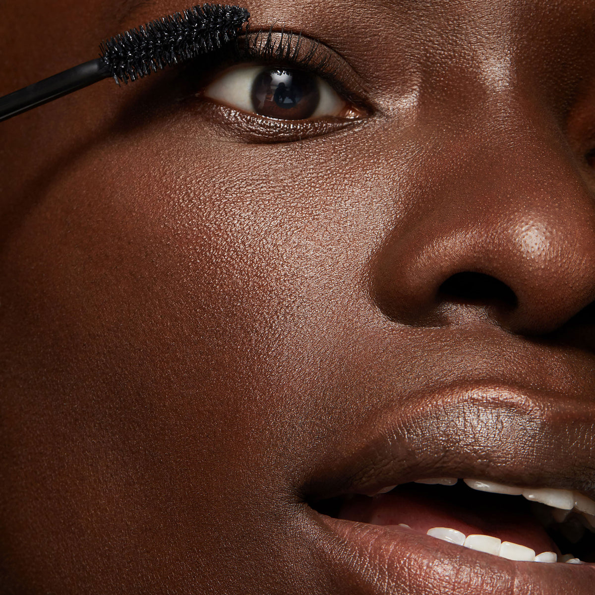 ColourPop Act Natural Mascara in Black brushing through upper eyelashes with a tapered bristle wand, close-up on a modelβs eye for defined, natural-looking length and lift.