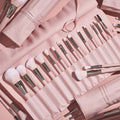 Total Smokeshow brushes fanned in a blush-pink roll-up case, featuring soft pink bristles, silver ferrules, and face and eye tools (powder, blending, angled, spoolie) from the ColourPop Shadow Palette & Brush Set, styled on a matching pink backdrop.