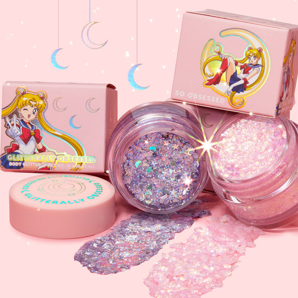 Open jars of Moonlight Legend ColourPop Glitter Gel shimmer in iridescent lilac and pink, with chunky holographic flakes and two thick swatches, surrounded by pastel pink Sailor Moon boxes and crescent-moon accents on a soft pink backdrop.