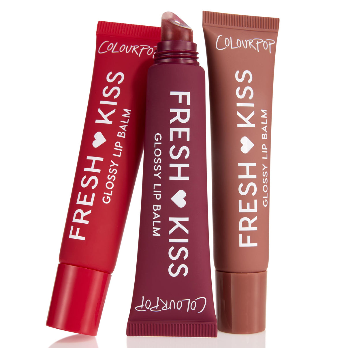 ColourPop Glossy Lip Balm Trio Get Rich tubes stand slightly angled, center tube uncapped to reveal a slanted applicator, in red, deep plum, and warm nude shades with Fresh Kiss branding on matte squeeze tubes against a white background.