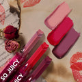 ColourPop So Juicy Plumping Gloss Balm with Peptides in Juicy Affair displayed as three heart-capped tubes, swatching glossy blush pink, cherry red, and plum, set diagonally on vintage text paper with lipstick kiss prints and dried roses.