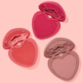 ColourPop Totally Lovestruck Heart Powder Blush Set displaying three open heart-shaped pressed powders in lip-shaped compacts - vivid fuchsia, warm coral, and soft nude pink - arranged diagonally on a pastel pink backdrop.