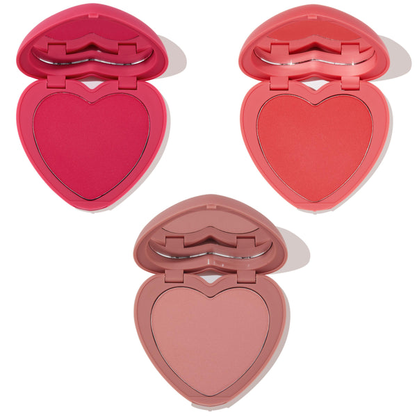 Three heart-shaped powder blush compacts from Totally Lovestruck, opened to reveal hot pink, vibrant coral, and soft nude rose shades with lip-shaped mirrors on a white background - ColourPop Heart Powder Blush Set for fresh, buildable color.