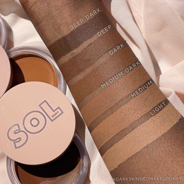 Forearm swatches show the ColourPop SOL Face & Body Bronzing Balm shade range - Light, Medium, Medium Dark, Dark, Deep, Deep Dark - while open SOL Body compacts rest on soft fabric, emphasizing the Light shade option.