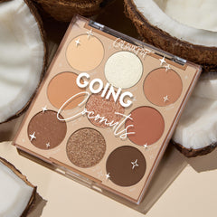 ColourPop Shadow Palette Going Coconuts lies open to reveal a 9βpan 3x3 grid of warm neutral browns and champagnes in matte and shimmer finishes, styled among cracked coconut halves on a beige surface.