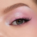 Shimmering pastel pink‑lilac eyeshadow blends across a close-up eyelid with fluttery lashes, showcasing the color payoff of the In A Trance shadow palette, a ColourPop Shadow Palette, perfect for soft, iridescent looks.