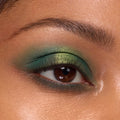 Eyelid showcasing a metallic lime-to-emerald green gradient from the Rainbow Rush Shadow Palette Set, ColourPop green eyeshadow look, with soft mascara and a defined brow in a tight close-up.