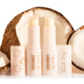 Coco Kisses ColourPop Lip Care Set displaying coconut lip scrub and lip balm in pale pink twist-up tubes with caps off, standing side by side in front of cracked coconut halves, with Fourth Ray Beauty branding on the caps.