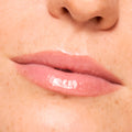 Close-up lips wearing a sheer baby pink, high-shine finish from Pretty in Pastels, a ColourPop Glossy Lip Balm Trio, showing hydrated, smooth texture and glassy sheen against natural skin in studio lighting.