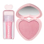 Heart to Get 2 Good 4 U blush and UGL set featuring a shimmery pink liquid lip gloss with a heart-shaped cap beside a matching sparkly pink heart-shaped powder blush compact with mirror on a clean white background.