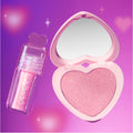 2 Good 4 U Blush + UGL Set from Heart to Get showing a shimmery pink heart-shaped blush compact with mirror and matching sparkly pink lip gloss tube with heart-shaped cap, floating on a glowing purple-pink gradient background with soft stars.