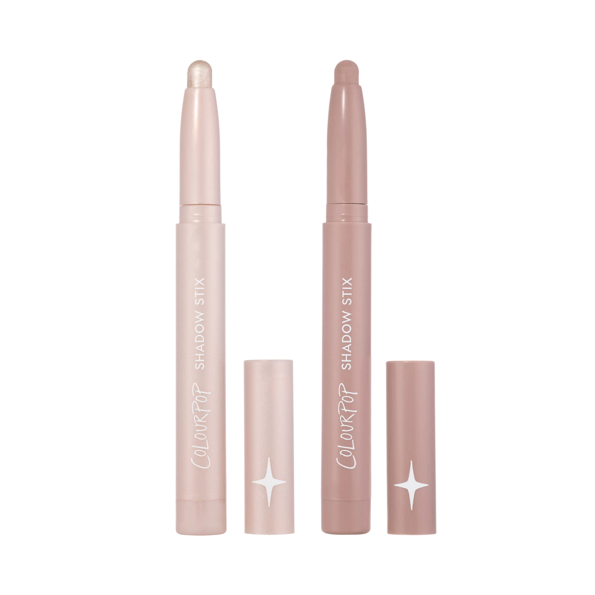 Two ColourPop Shadow Stix from the For Your Eyes Only Heart to Get kit stand upright with caps off, showing shimmery champagne and matte mauve cream eyeshadow sticks against a clean white background.