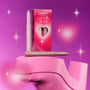 ColourPop For Your Eyes Only Shadow Stix from the Heart to Get collection standing beside its pink gradient box with heart-shaped cutout, styled on glossy pink heels against a sparkling magenta background.