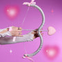 Hand draws a glittery silver bow with a pink heart-shaped arrow reading ColourPop, styled on a dreamy pink background to tease the Not Your Baby Heart to Get Super Shock Blush Valentine-inspired makeup collection.