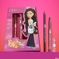 Yasmin ColourPop Lippie Kit, a Bratz collab, displays the boxed set with Bratz artwork next to an uncapped lippie pencil and Lippie Stix in rosy-brown shades, standing upright against a pink gradient background for a nostalgic lip duo gift.
