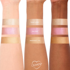 Pink Pony ColourPop Liquid Highlighter swatched on three arms, showing a luminous pink pearl sheen between shades Sugar Donut and Immediately, Yes; reflective shimmer across light, medium, and deep skin tones for easy shade comparison.