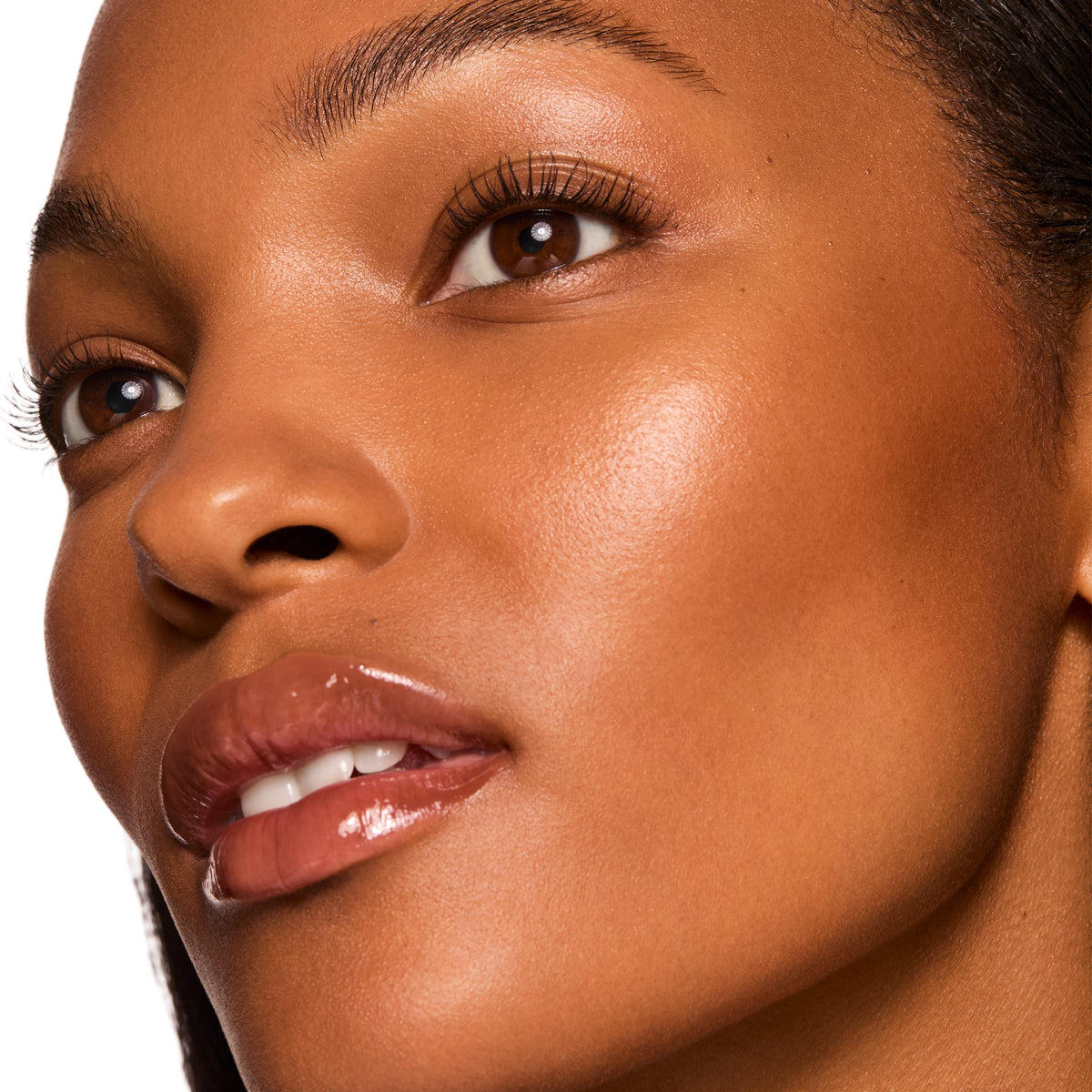 Immediately Yes ColourPop Liquid Highlighter adding a soft luminous glow to a model’s cheekbone and brow bone in a tight face close-up, showcasing smooth skin and glossy nude lips.