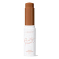 ColourPop Pretty Fresh Tinted Foundation Balm, shade Dark 20, stands uncapped with the twist-up stick exposed in a deep warm brown, housed in a white tube labeled Pretty Fresh against a clean white background.
