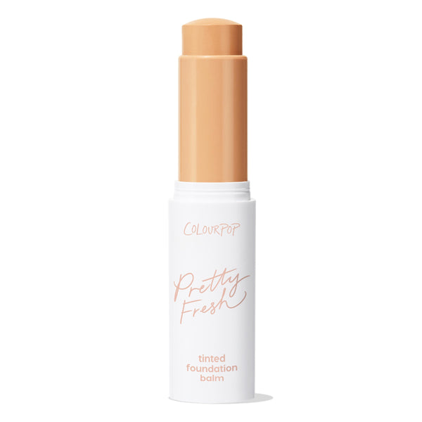 ColourPop Pretty Fresh Tinted Foundation Balm, shade Medium 11, shown twisted up in a white stick with peach lettering, cap off to reveal a warm medium-beige balm, standing upright against a clean white background.
