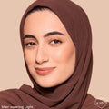 Model wearing ColourPop Pretty Fresh Tinted Foundation Balm in Light 7, showcasing smooth, natural dewy coverage; close-up face in a brown headscarf against a beige background to display the true shade and finish.
