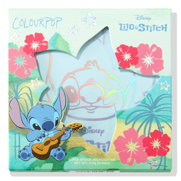 Ohana ColourPop Super Shock Highlighter compact displayed in a teal Disney Lilo & Stitch box, star-shaped window revealing the pan and holographic Stitch art, framed by red hibiscus and palms; 4.0 g (0.14 oz) collab makeup.