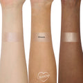ColourPop Super Shock Highlighter in Ohana swatched in wide stripes on three forearms (light, medium, deep), revealing a pink champagne shimmer with smooth, high-shine payoff; center swatch labeled OHANA on a clean white studio background.