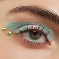 ColourPop Crystal Face Jewels Individual accenting the outer corner of an eye - two lime green round crystals placed beside iridescent mint‑teal eyeshadow in a close-up beauty look, perfect for standout festival makeup.