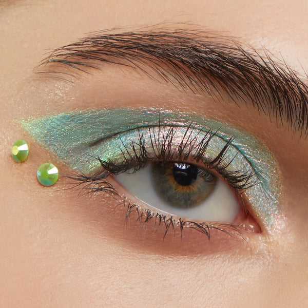 ColourPop Crystal Face Jewels Individual accenting the outer corner of an eye - two lime green round crystals placed beside iridescent mint‑teal eyeshadow in a close-up beauty look, perfect for standout festival makeup.