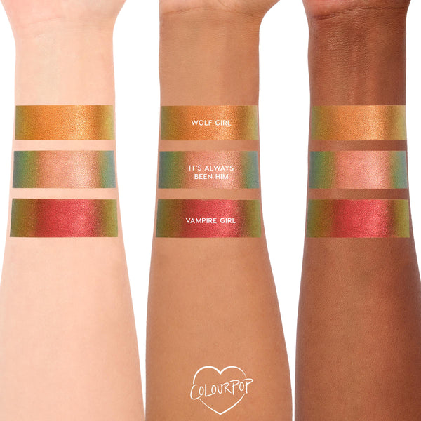 ColourPop Shadow Stix in Wolf Girl swatched on three arms (light, medium, deep); top stripe shifts green to gold-orange. Lower stripes show It’s Always Been Him (peachy pink with teal shift) and Vampire Girl (red with green shift) for comparison.