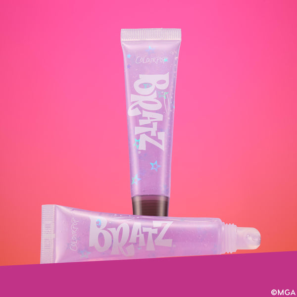 Bratz x ColourPop lip gloss tubes in lavender, star-studded squeeze packaging - one standing, one lying with a slanted applicator tip - on a pink gradient background, promoting the Bratz x ColourPop Full Collection, a ColourPop Full Collection Set.