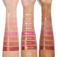 Three forearms display Plump Perfect swatches from the ColourPop So Juicy Lip Oil Set, showing glossy shades Lychee Jelly, Flirty Text, Baby Panda, It’s a Date, Trending Now, So Sassy, Hits Diff, and Beverly Drive on light, medium, and deep skin tones.