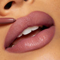 ColourPop Group Chat So Juicy Plumping Lip Liner with Peptides lining full lips in a mauve‑nude shade, pencil tip defining the cupid’s bow for a smooth, glossy, fuller look in a tight close-up.
