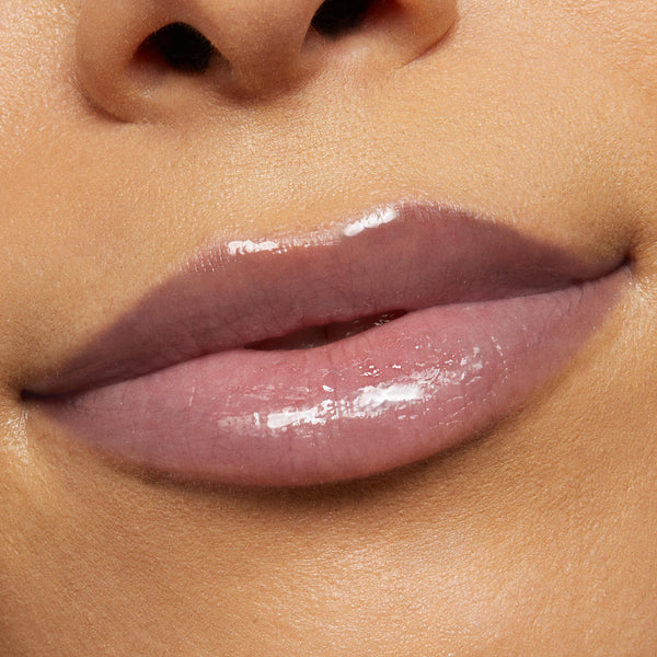 Glossy lips wearing Vampy Lips Lux Lip Oil, delivering a sheer cool-toned mauve shine; ColourPop Lux Lip Oil formula adds hydrating, high-shine finish in a tight close-up beauty shot.
