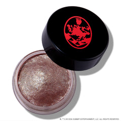 Open ColourPop Cullen Coven Jelly Much Shadow, a shimmery metallic taupe cream eyeshadow inspired by Twilight, sits in a clear round jar with a tilted black lid featuring a bold red crest logo on a white background.