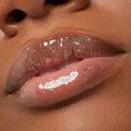 Glossy lips wearing iridescent, holographic glitter, catching light in a macro close-up to showcase the ColourPop Ultra Glossy Lip from the Stranger Things x ColourPop Full Collection, a full collection set delivering a glassy, sparkly finish.