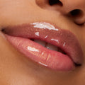 Shimmering peachy-pink lips wear a high-shine, gold-flecked gloss, showcasing the Type Advantage ColourPop Lip Set; extreme close-up of slightly parted lips highlighting a smooth, glassy finish and sparkle.