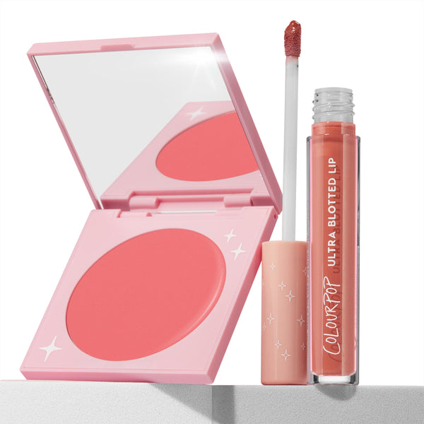Mood 24/7 ColourPop Cheek & Lip Set showcases an open pink blush compact with mirror and star accents alongside an Ultra Blotted Lip tube with wand dipped in a peach-coral shade, set on a white ledge in a clean studio.