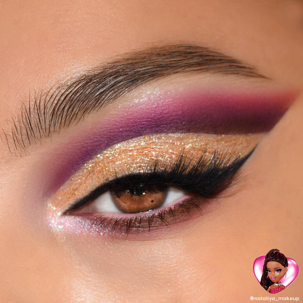 Gold glitter cut-crease eyeshadow with a sharp black wing and voluminous lashes on a brown eye, blended into rich purple and magenta, showcasing the Bratz x ColourPop Full Collection from the ColourPop Full Collection Set with a Sasha-inspired badge.