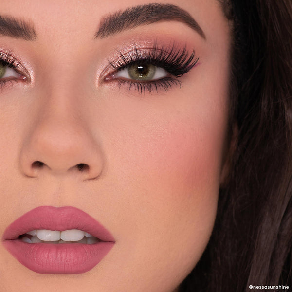 Heart to Heart blush adds a soft peachy‑rose flush to the model’s cheek in a studio close‑up, paired with shimmery pink lids, bold lashes, and mauve lips - ColourPop Heart Powder Blush Set showcasing a natural matte finish.