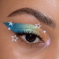 White Graceland BFF Liquid Liner tracing crisp star accents around a brown eye over a teal-to-gold-to-peach shimmer wing; ColourPop BFF Liquid Liner defines the graphic look beneath natural lashes and a neatly groomed brow.