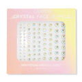 ColourPop Crystal Face Jewels Individual sheet displaying 81 iridescent round adhesive crystals in varied sizes arranged in neat rows, set in pastel pink-to-yellow ombré packaging for customizable face accents.