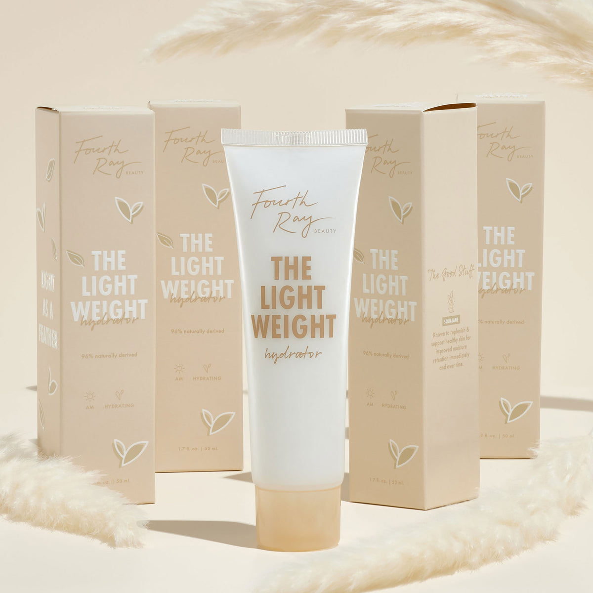 Fourth Ray Beauty The Lightweight hydrator tube standing upright, a ColourPop Face Moisturizer, gold lettering, 1.7 fl oz, surrounded by matching beige cartons and soft pampas accents on a warm cream backdrop.