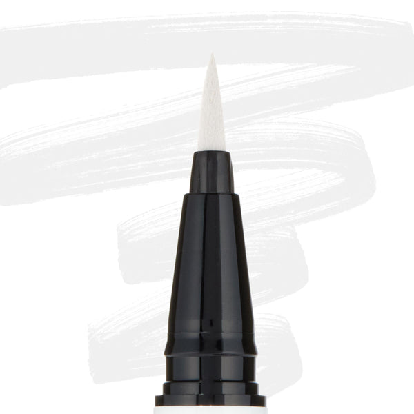 ColourPop BFF Liquid Liner Graceland creating bold white strokes with a fine felt tip; close-up of the black pen barrel and pointed brush, white eyeliner swatches behind, for precise wings and graphic eye looks.