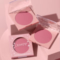 ColourPop New to U pressed powder blush compact opens to reveal a soft rosy‑mauve pan, flanked by a second open compact and a boxed unit, styled on pastel pink blocks; clear lids and star accents brand the ColourPop Pressed Powder Blush.