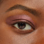 Rosy-plum metallic eyeshadow sweeps across a model’s eyelid, showcasing So Into U ColourPop Shadow Stix with smooth, blendable coverage and a high-shine finish in a close-up beauty swatch.