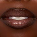 Lips wearing ColourPop Ultra Glossy Lip in Coffee Break, showing a rich coffee-brown, high-shine finish in an extreme close-up of a slightly parted mouth, highlighting smooth, glassy coverage and a plush, glossy nude look.