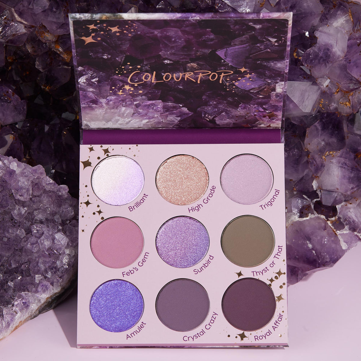Open All Amethyst ColourPop Shadow Palette displays nine purple-toned shades - lilac, lavender, mauve, plum, and taupe - in matte and shimmer finishes (Brilliant, High Grade, Sunbird, Crystal Crazy), set against raw amethyst crystals.