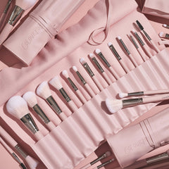 Total Smokeshow brushes fanned in a blush-pink roll-up case, featuring soft pink bristles, silver ferrules, and face and eye tools (powder, blending, angled, spoolie) from the ColourPop Shadow Palette & Brush Set, styled on a matching pink backdrop.